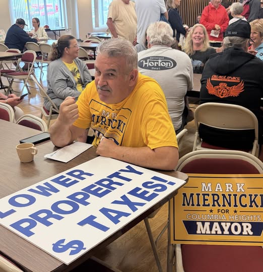 Campaign issue sign and Mark Miernicki for Mayor sign at an indoor event